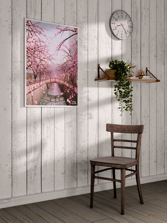 Low poly framed poster capturing a canal in tokyo bordered with sakura in bloom, on a whitewashed coastal wall